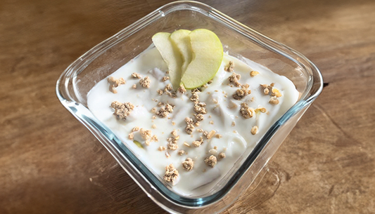 Apple pie overnight weetabix in een glazen schaal op een houten tafel