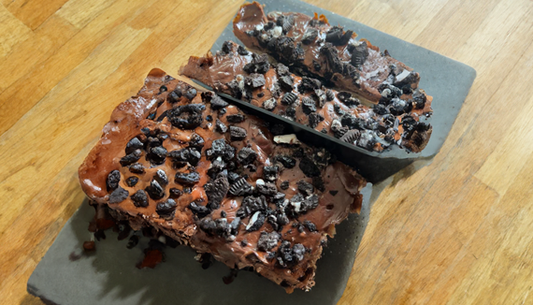 op een metalen plaat gepresenteerd Chocolate Oreo cheesecake bars op een houten tafel