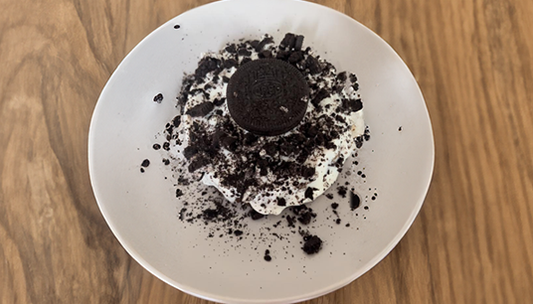 In een wit bord No bake chocolate Oreo cake op een houten tafel