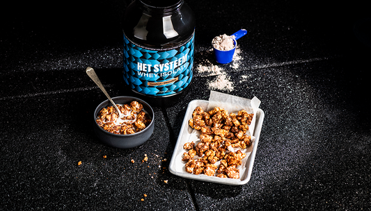 een productfoto in een donkere setting met Het Systeem whey isolate hazelnut en chocolate en een schaal met Ricecake cereal